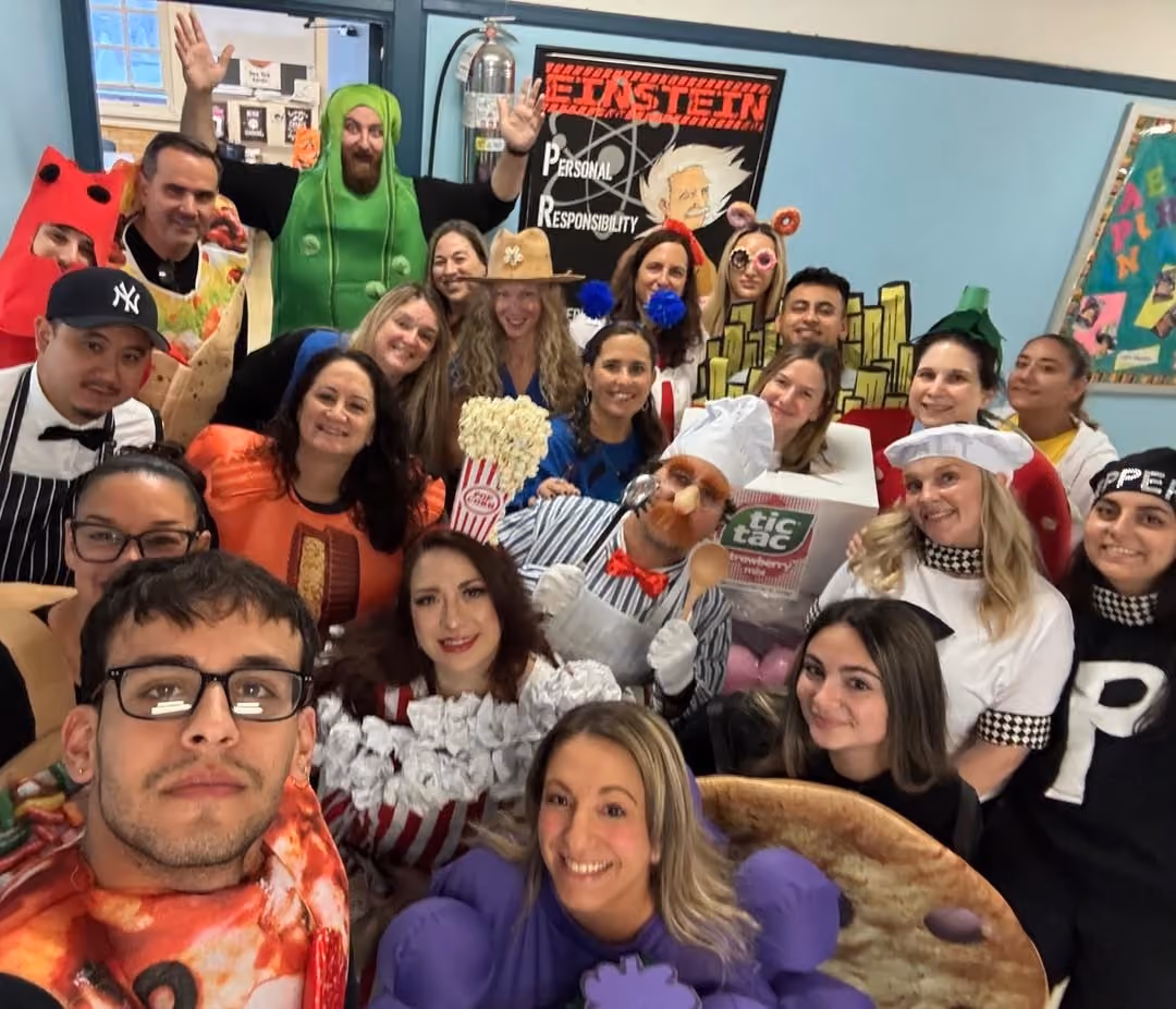Teachers in Halloween costumes taking a group selfie