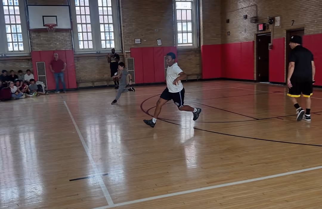 Harlem Magic Masters players running a basketball drill in the gym