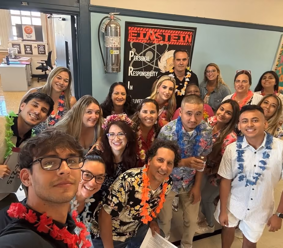 Staff in Hawaiian shirts and leis taking a welcome-back group selfie