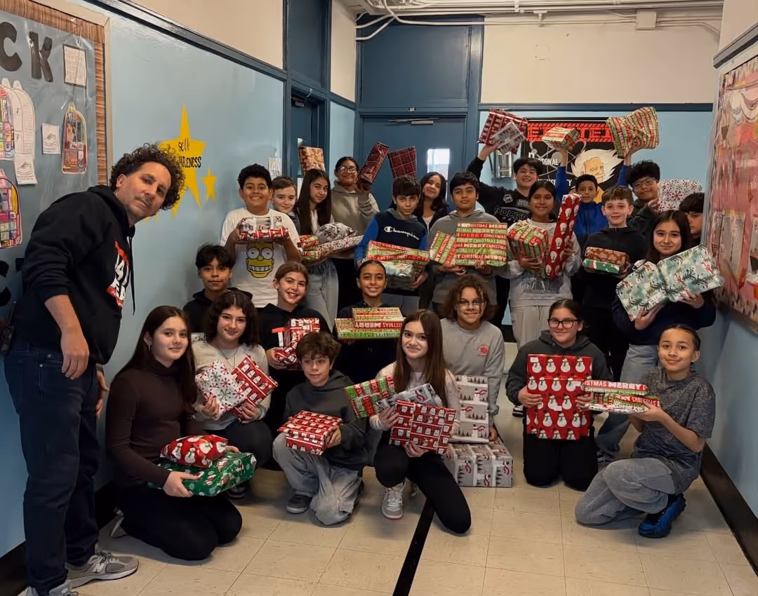 Students holding wrapped gifts collected for the Snowflake Drive