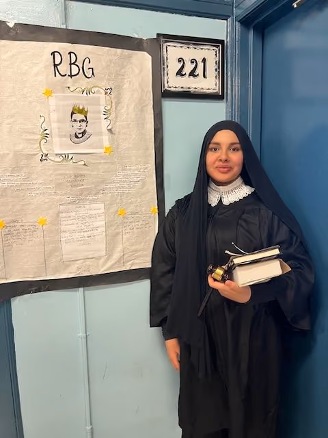 Student dressed as Ruth Bader Ginsburg in a judge's robe for the Living Wax Museum