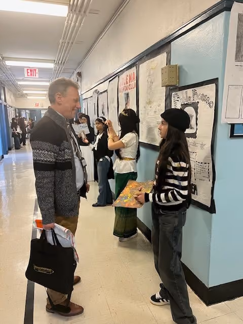 Special guest Dr. Fahey listening to a student presentation at the Living Wax Museum
