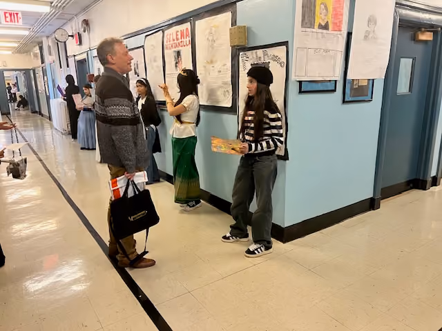 Dr. Fahey walking the hallway as students present at the Living Wax Museum