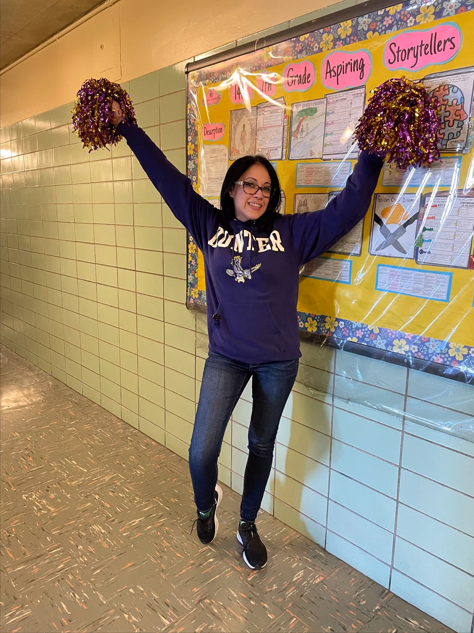 Student cheering with pom-poms in a Hunter College sweatshirt on Career Day