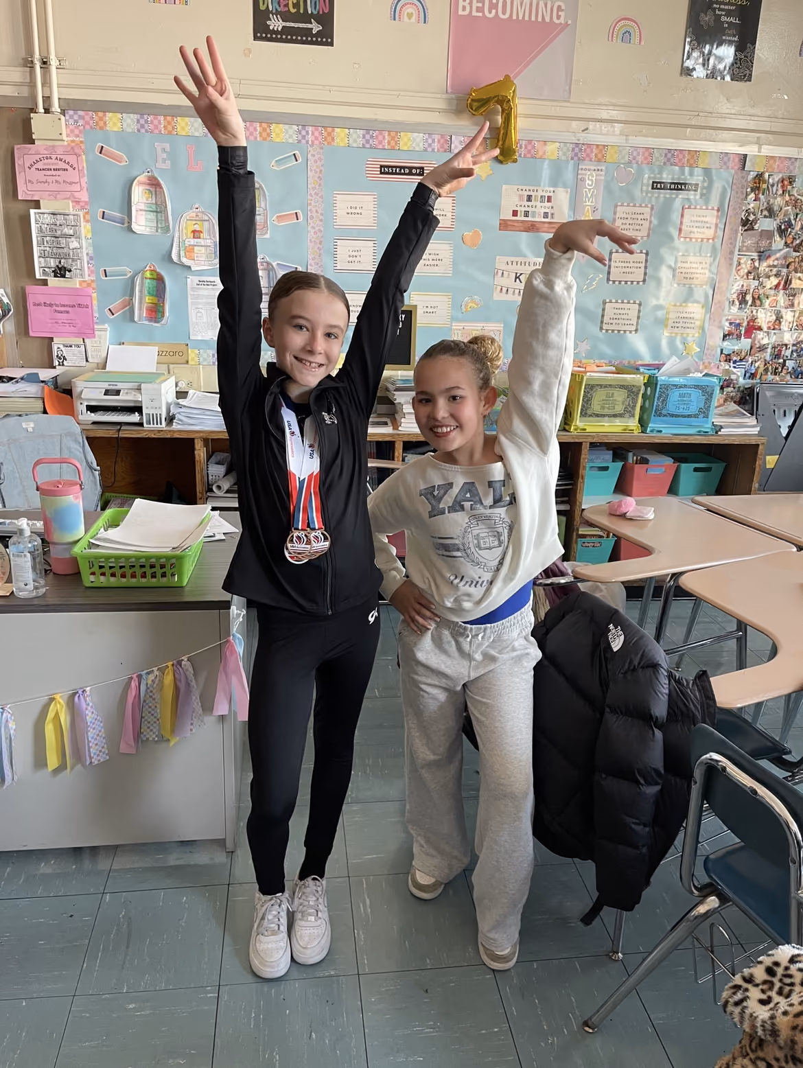 Two students posing in athletic outfits with medals on Career Day