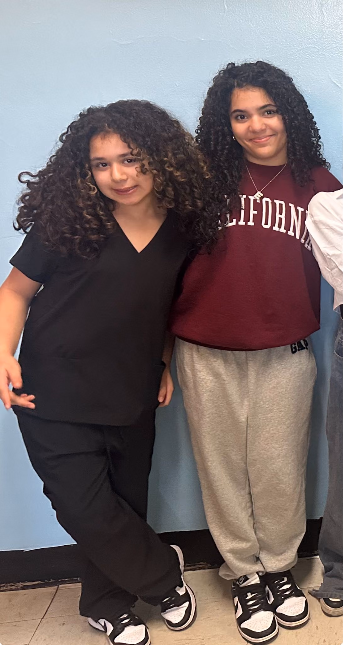 Two students in scrubs and a college sweatshirt on Career Day