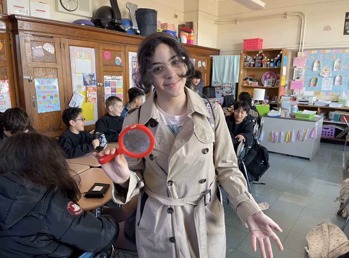 Student dressed as a detective with a magnifying glass on Career Day