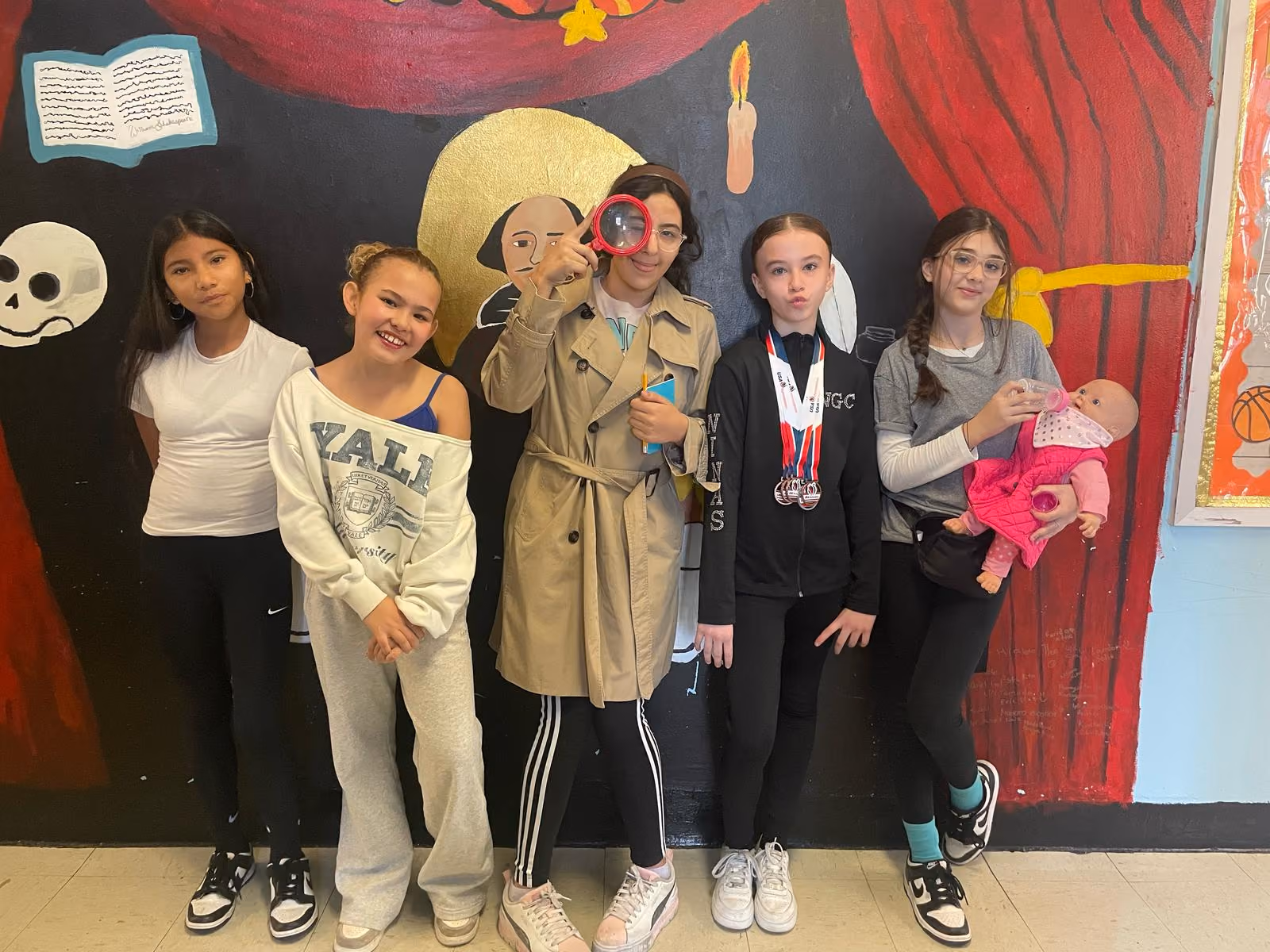 Group of students in career costumes posing in front of a painted mural