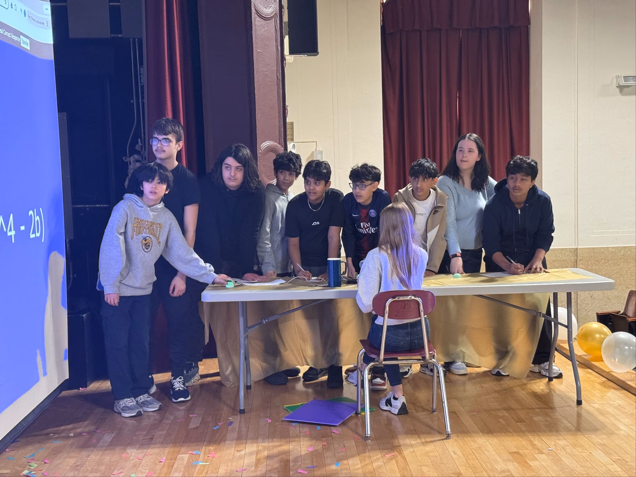 Student team standing at their table on stage during MAA and RBG Jeopardy