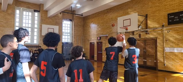 I.S. 141 basketball players in red and black jerseys during a game