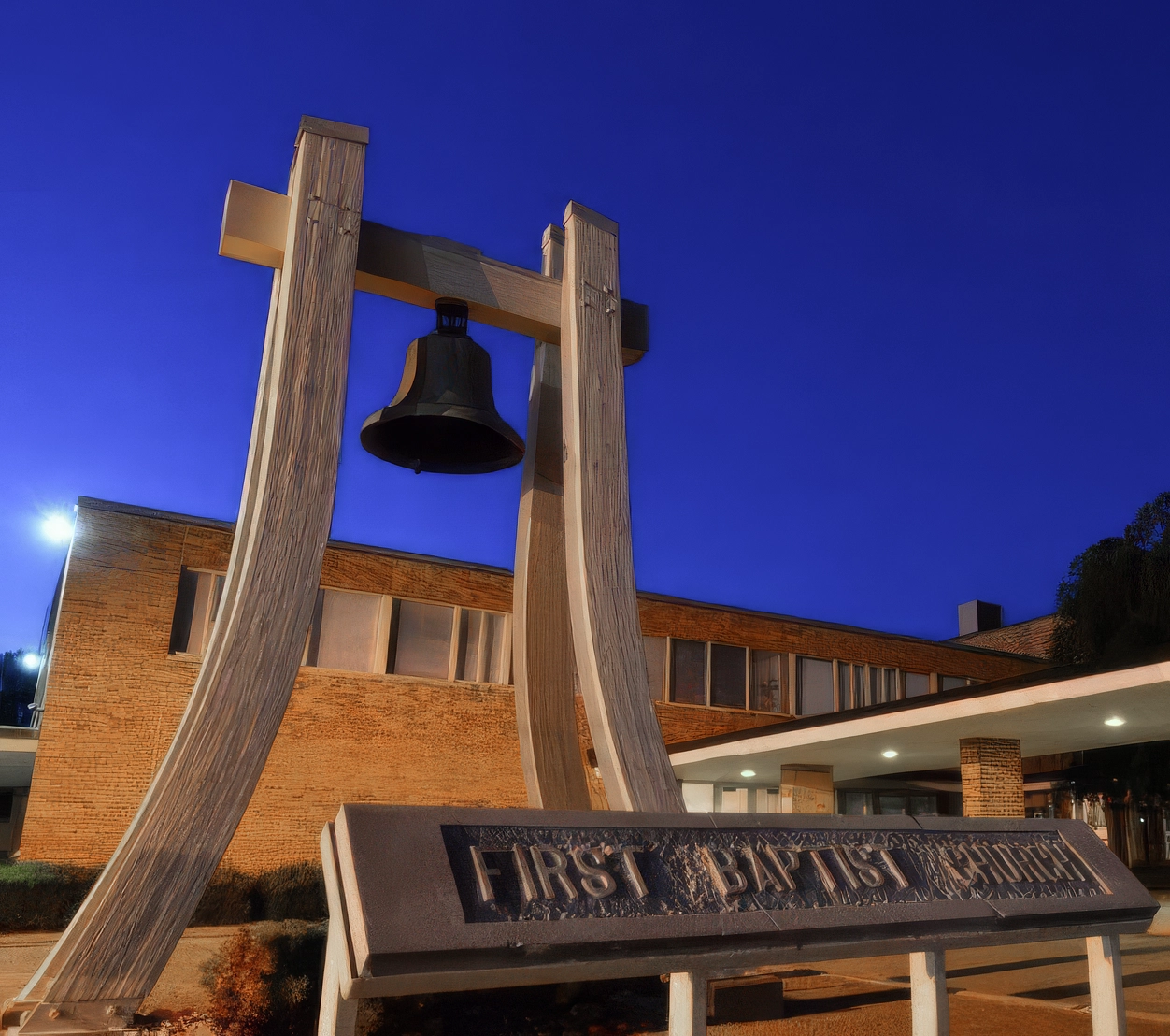 The bell tower and First Baptist Church sign at dusk