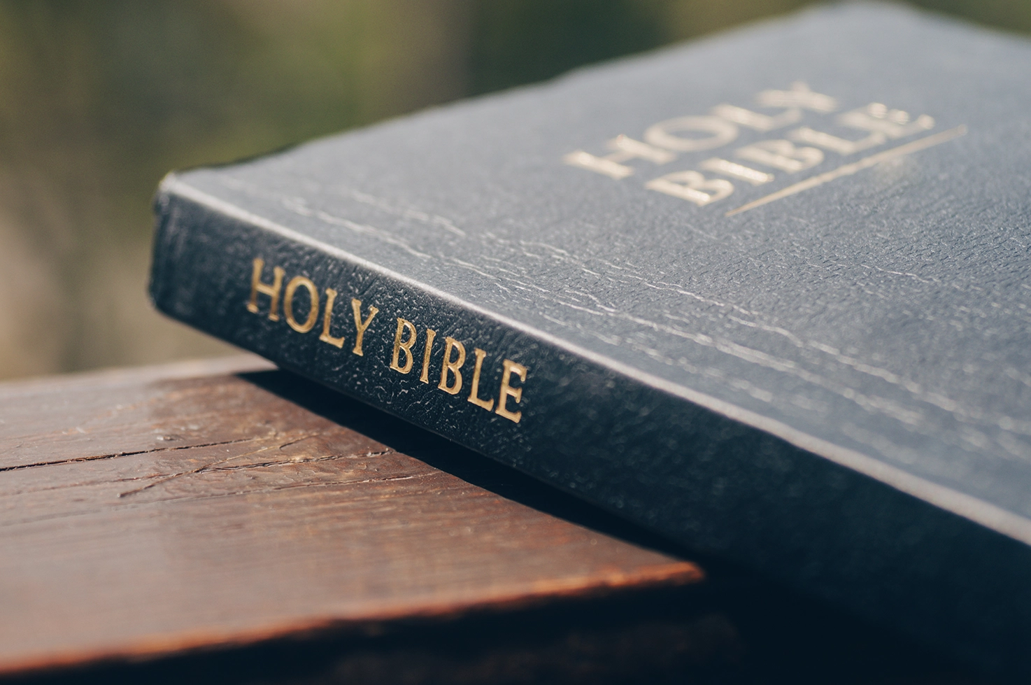 An open Bible resting on a wooden bench