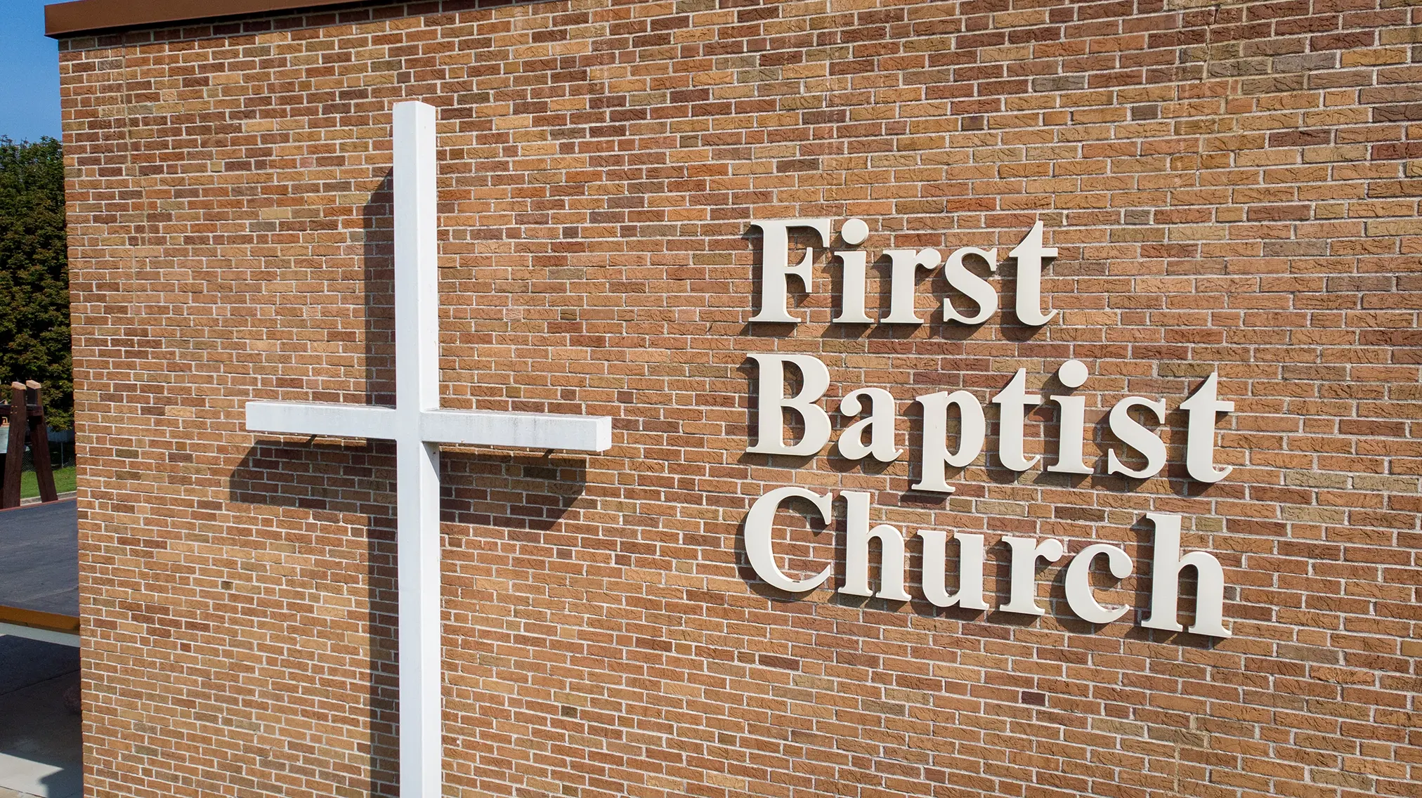 The cross and First Baptist Church lettering on the brick exterior