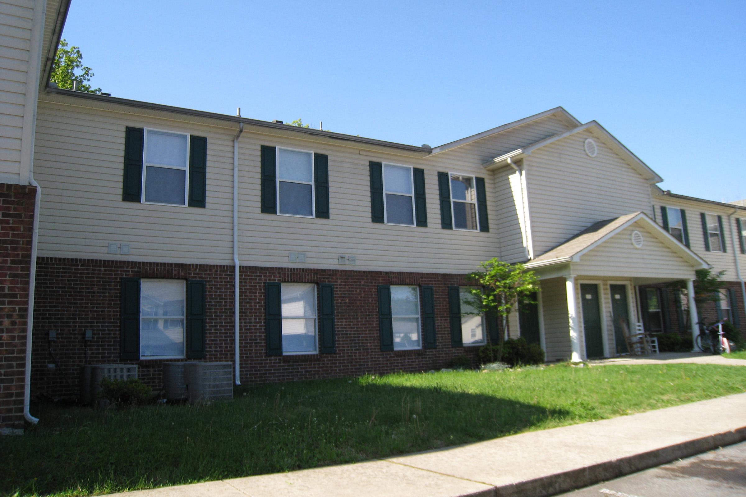 Apartment building exterior with brick base and light siding