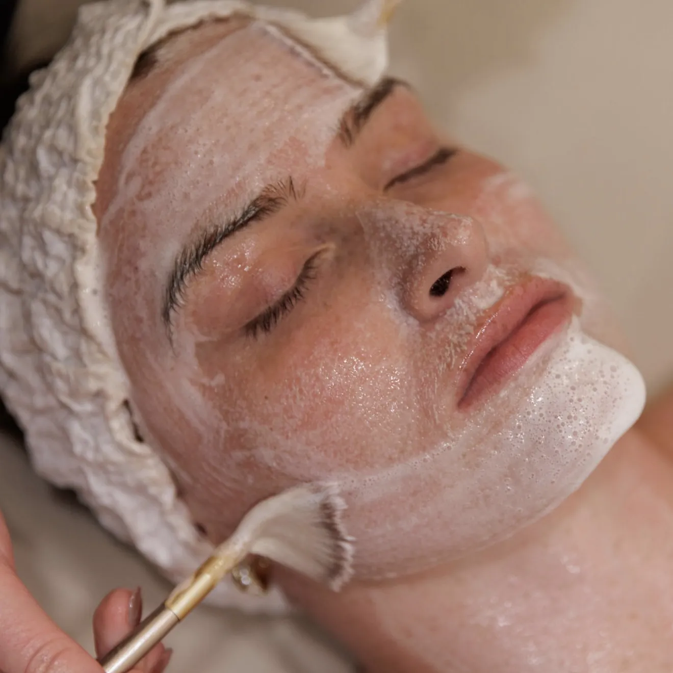 Esthetician applying a treatment to a client during a skin treatment