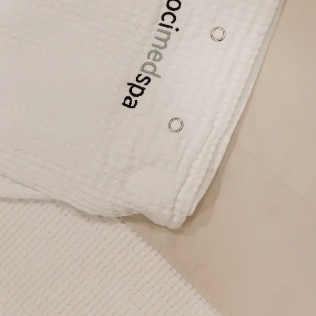 Close-up of a white Voci MedSpa robe