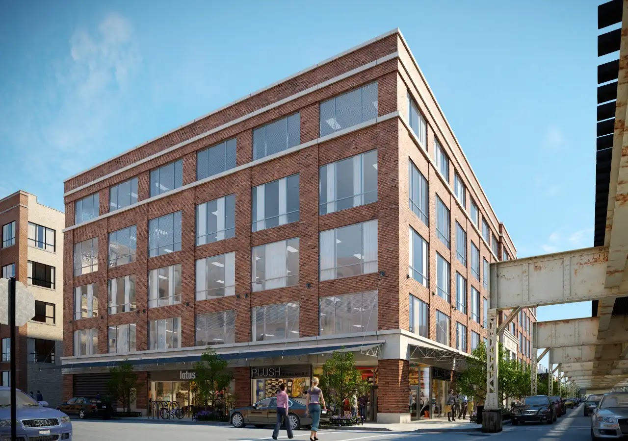 Exterior view of a mixed-use brick building with storefronts.