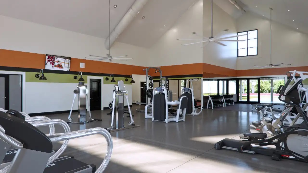 Modern gym interior with workout equipment and large windows.