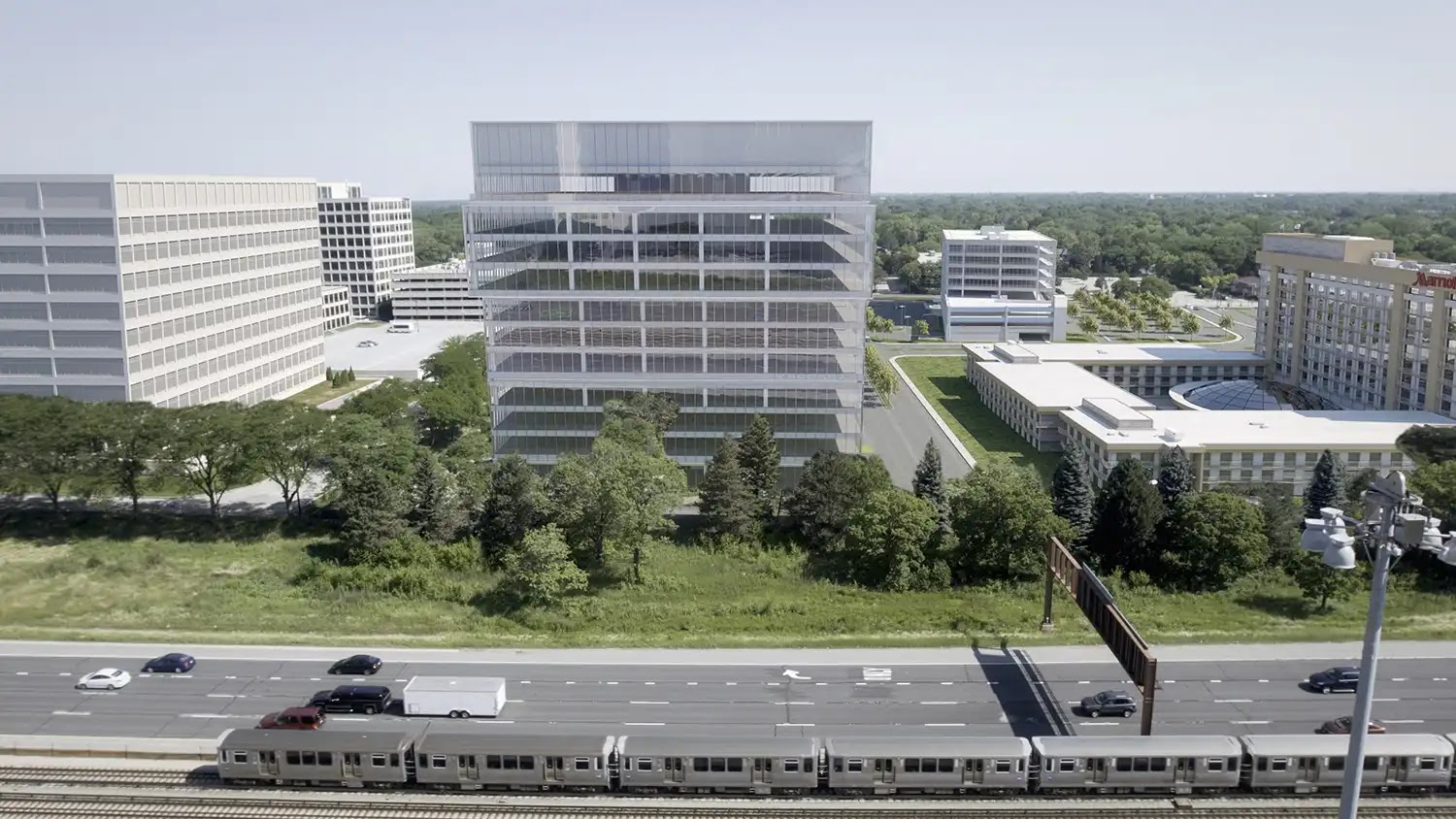 Aerial view of a modern glass office building surrounded by trees and roads.