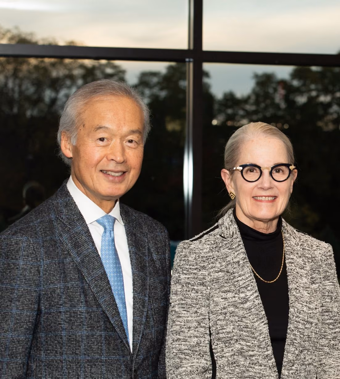 Founder Tachi Yamada and wife posing in front of window