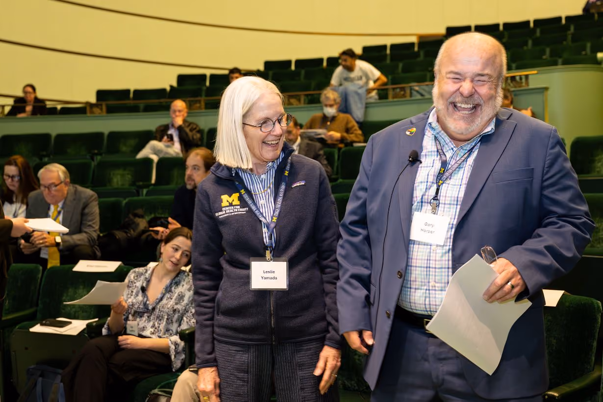 Two members laughing together at Center for Global Health Equity research symposium at University of Michigan
