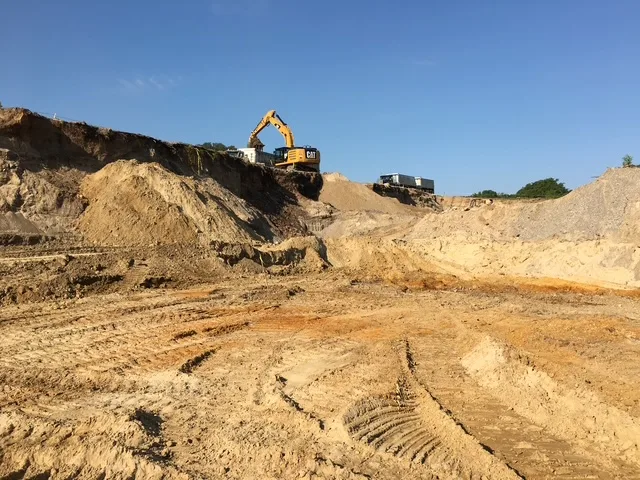 excavator at top of excavation site