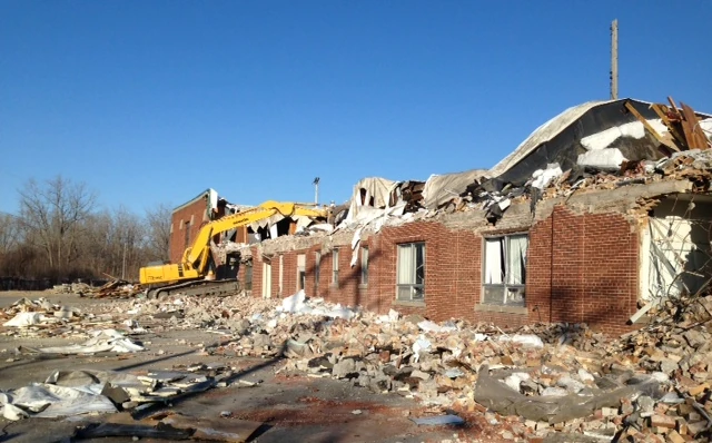 building demolished by excavator