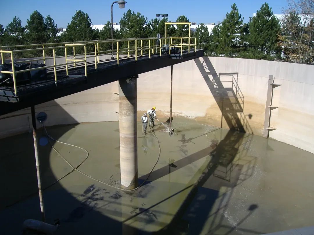 worker spraying inside of industrial tank