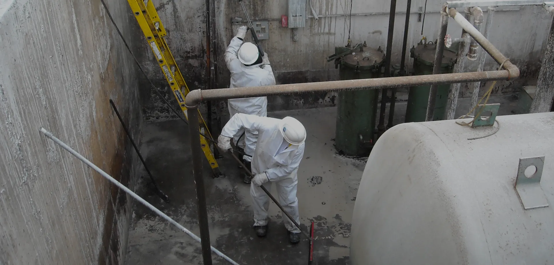 cleaning inside of industrial tank in protective equipment