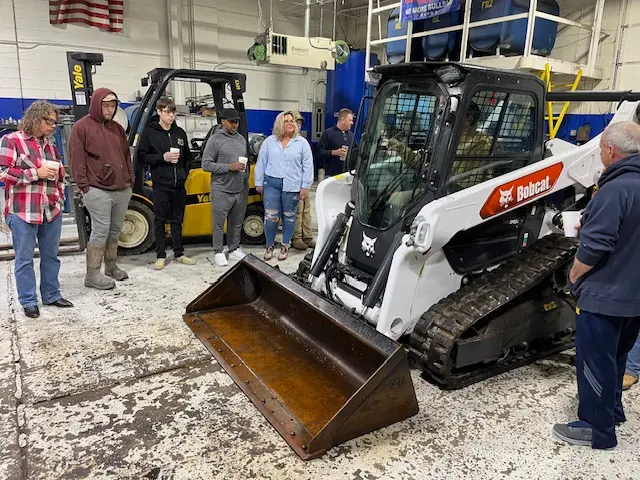 group of people watching worker in equipment