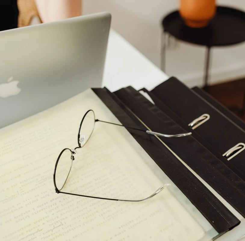 lunettes sur dossier et ordinateur