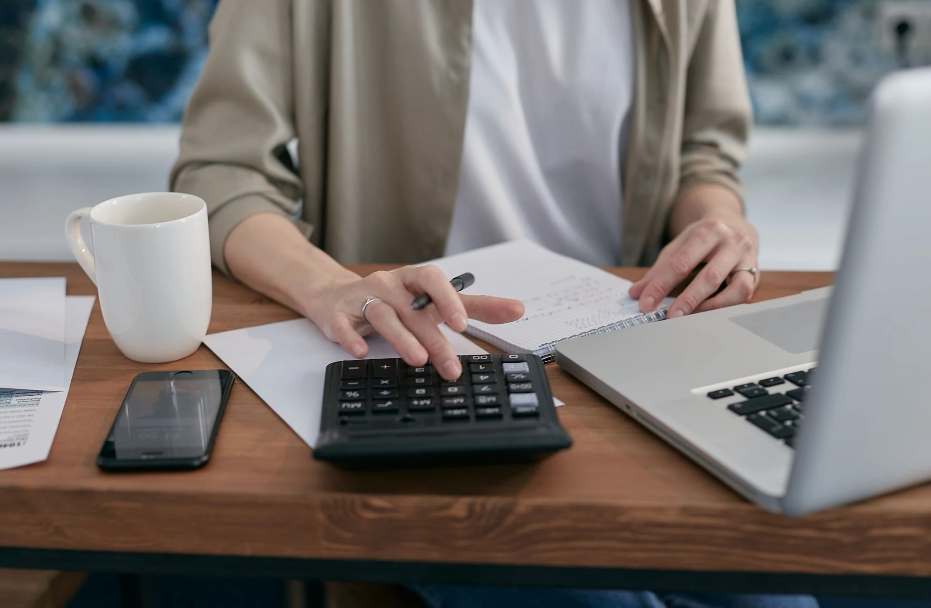 femme qui calcule devant son ordinateur avec une tasse