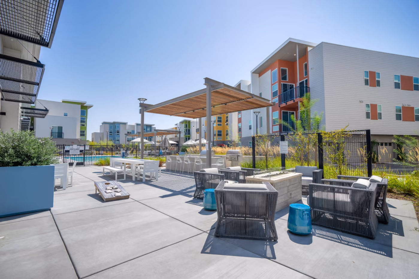 Outdoor lounge area with pergola, seating, and fire pits