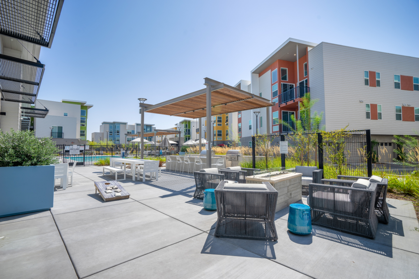 Outdoor lounge area with pergola, seating, and fire pits