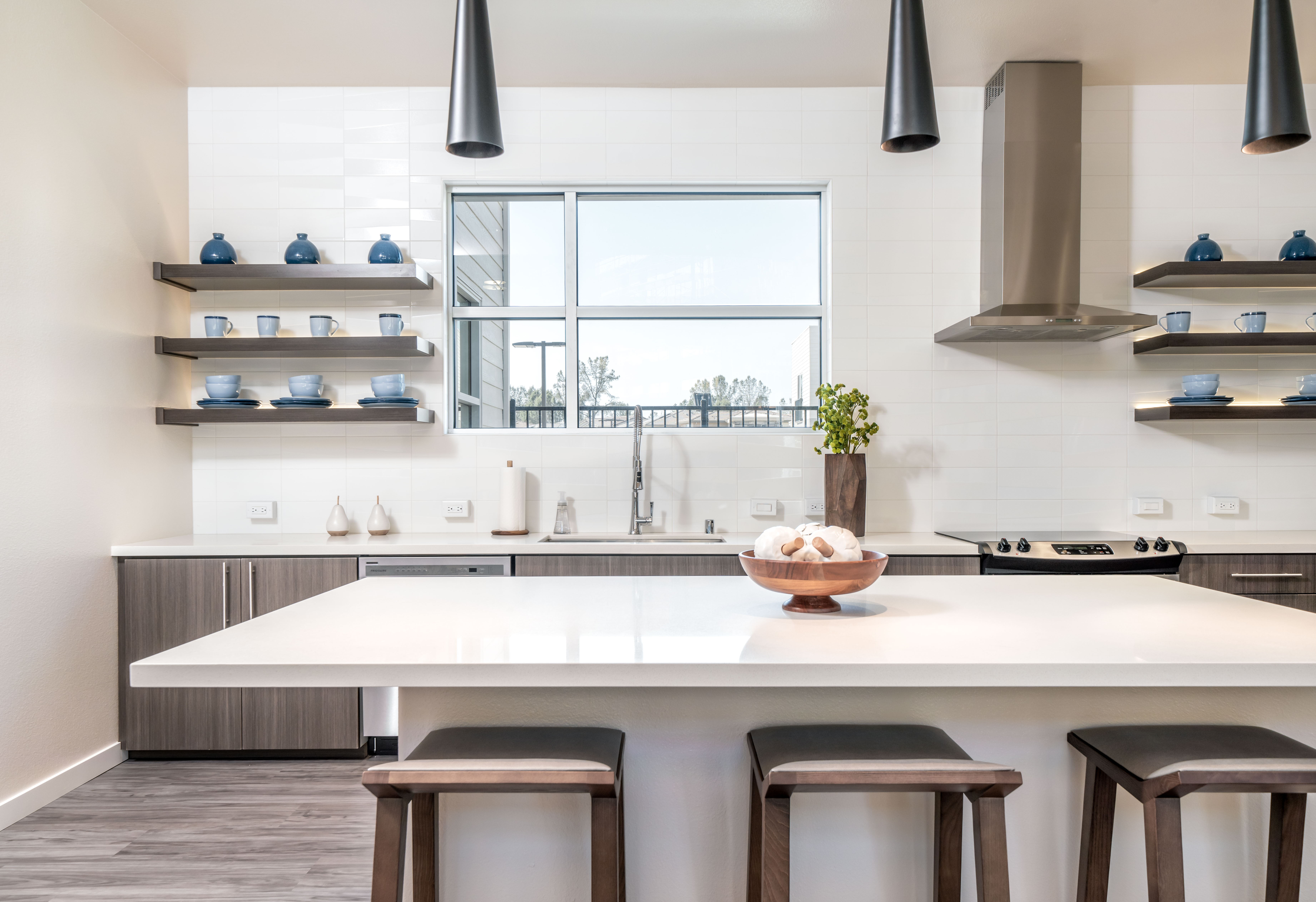 Community kitchen with island and shelves with dishes
