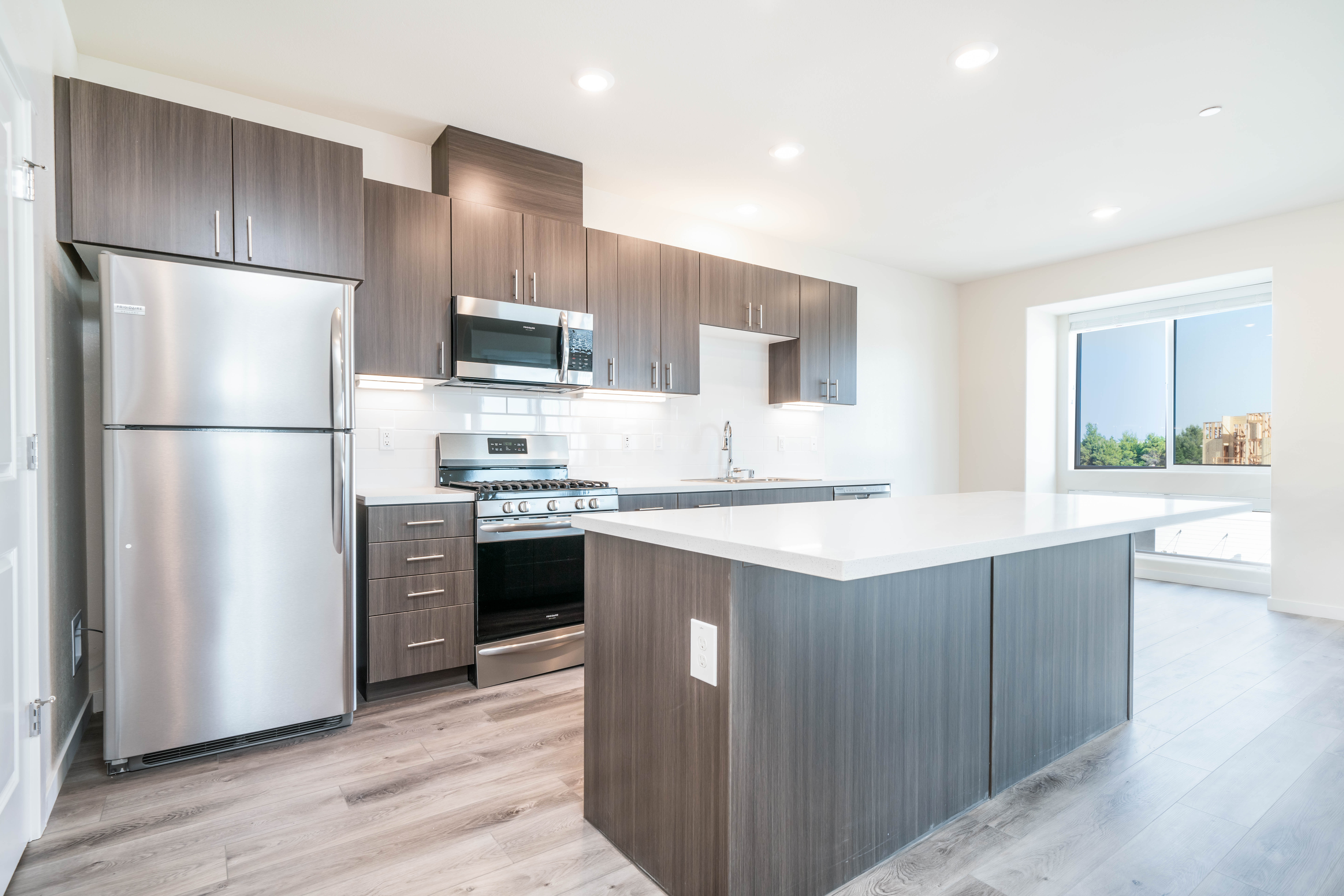 Kitchen with dark cabinetry, center island, and stainless steel appliances