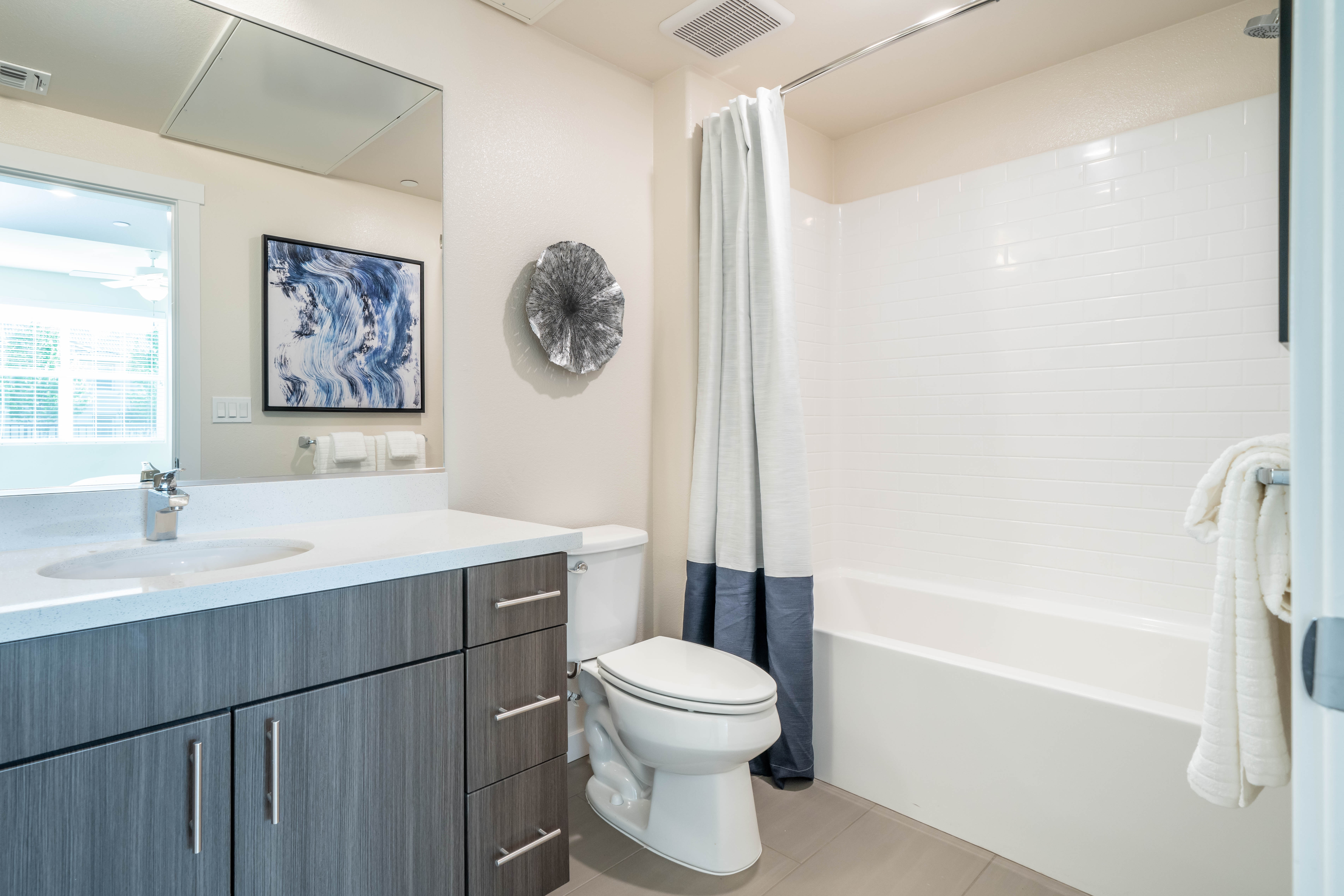 Bathroom with vanity, brown cabinets and shower tub combo
