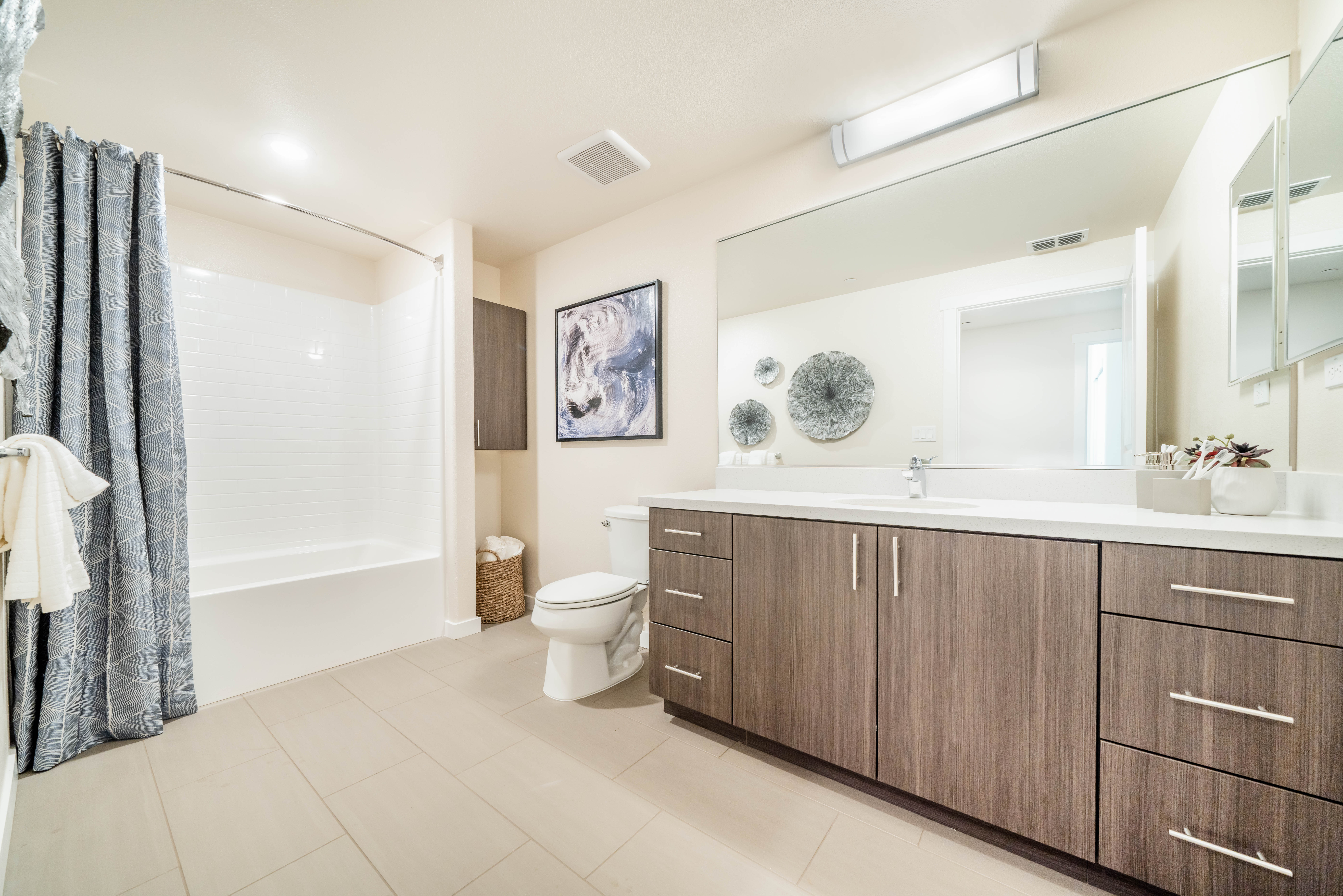 Bathroom with vanity, brown cabinets and shower tub combo
