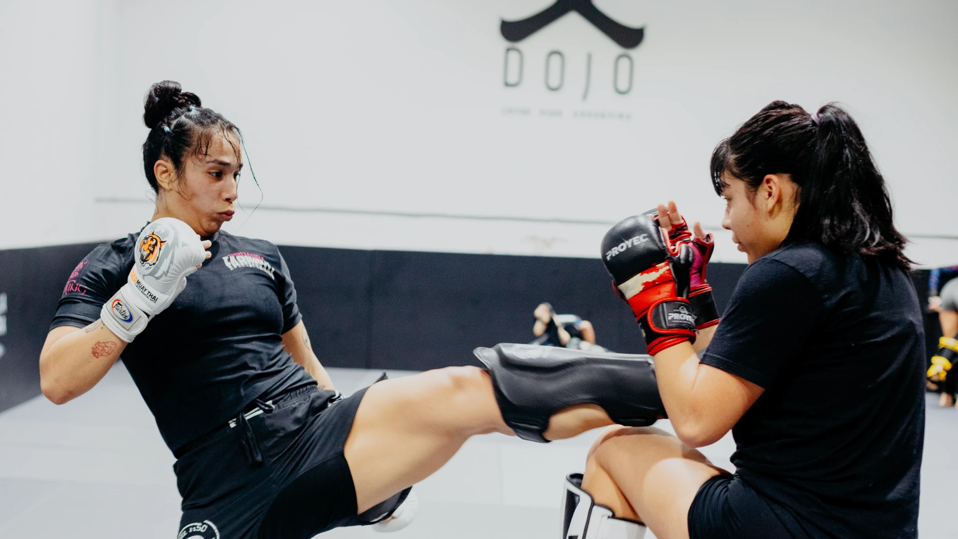 Two athletes practicing Muay Thai striking techniques at Dojo Nine.