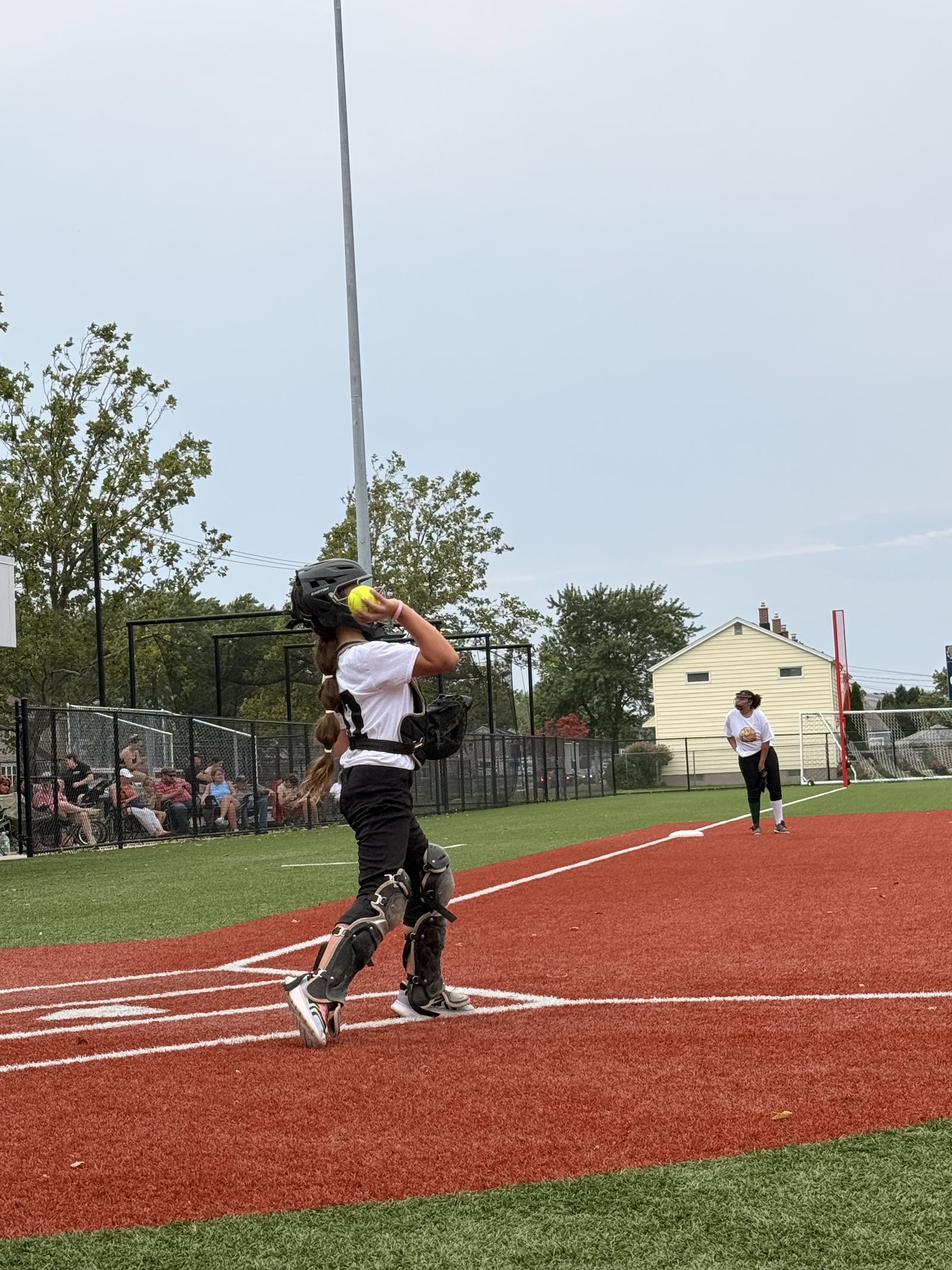 A catcher in full gear sets up behind the plate.