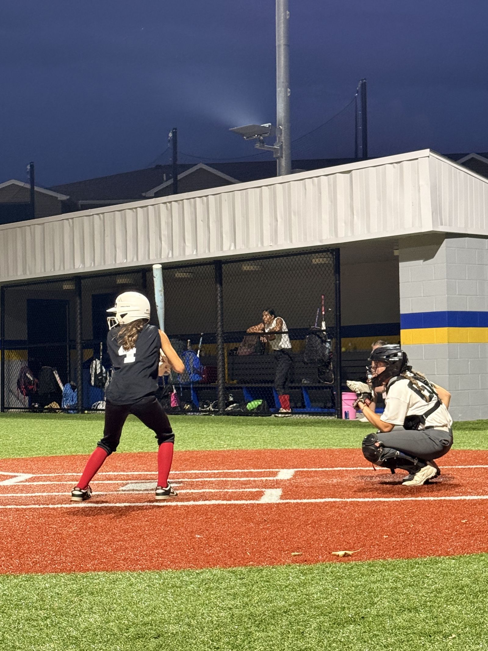 A batter settles into the box as the catcher sets up.