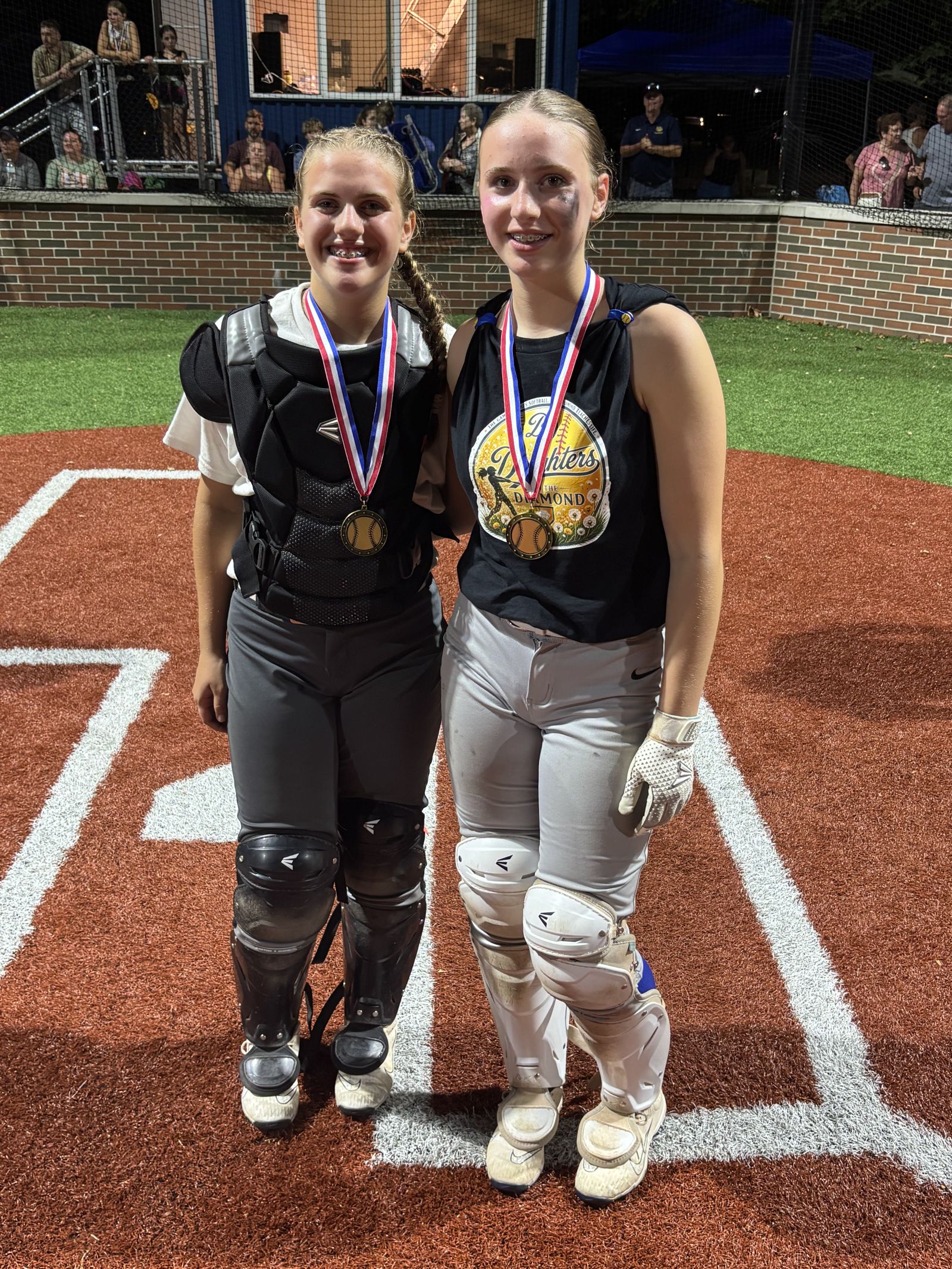 Two players with their medals at home plate.