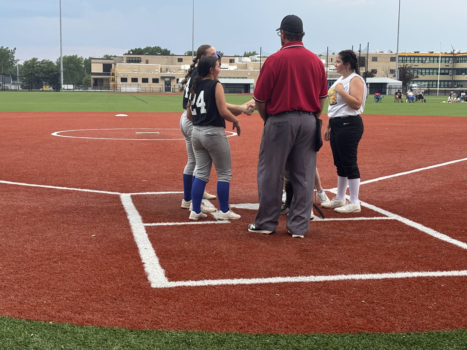 Players and coaches meet at home plate before the game.
