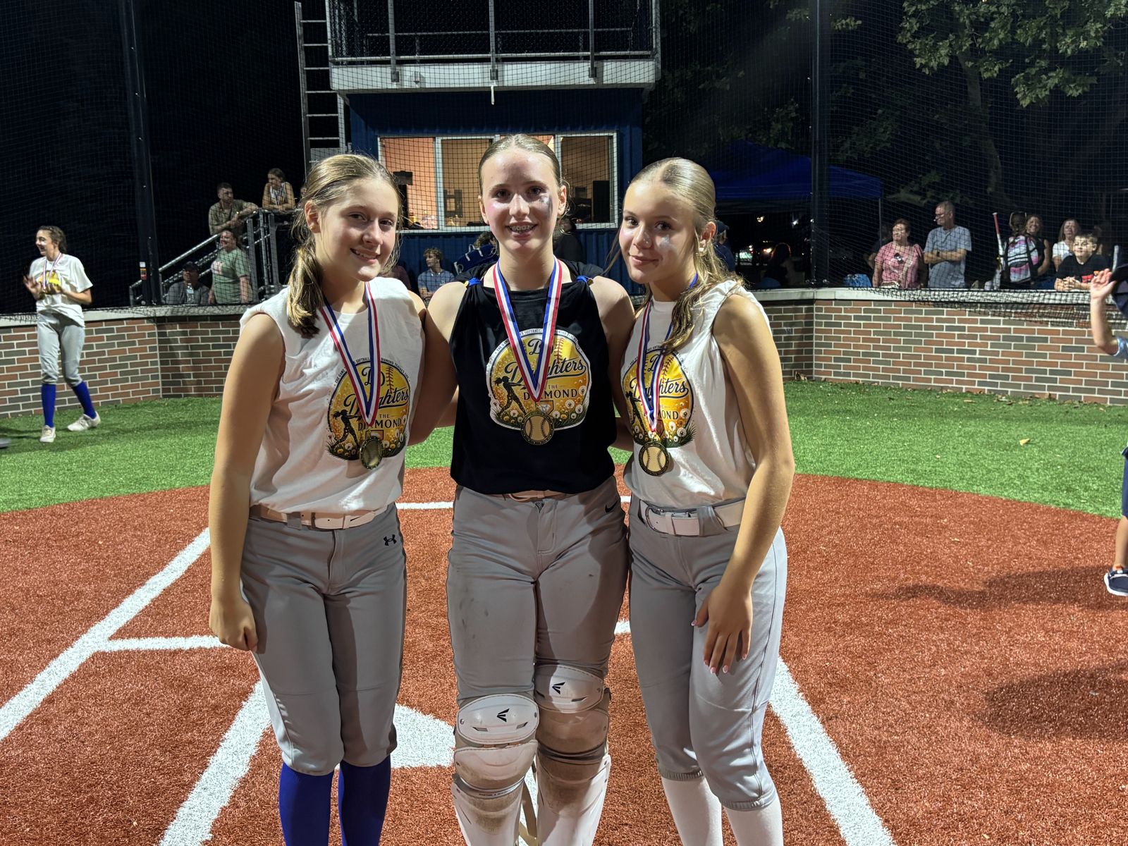Three players with medals on the infield.