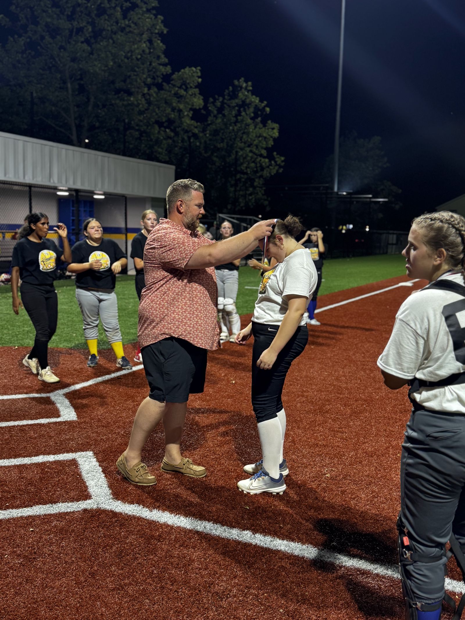 A coach places a medal on a player.