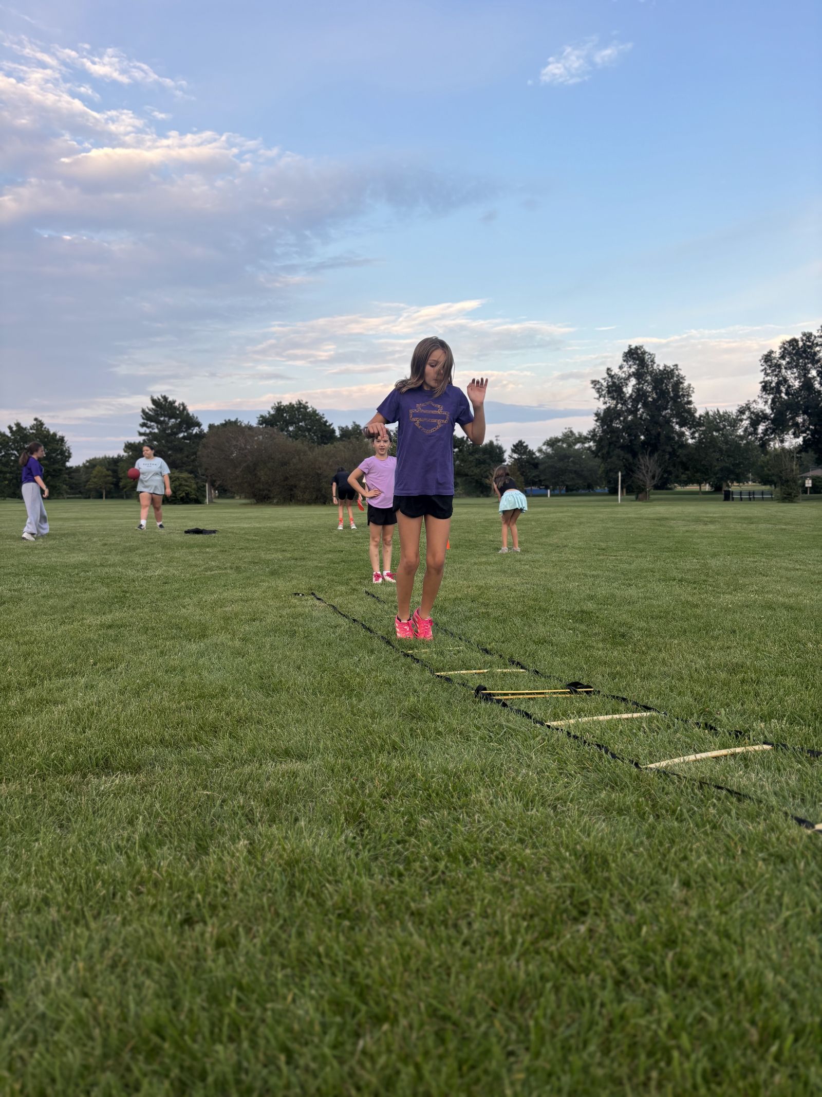 A line of players works through footwork drills.
