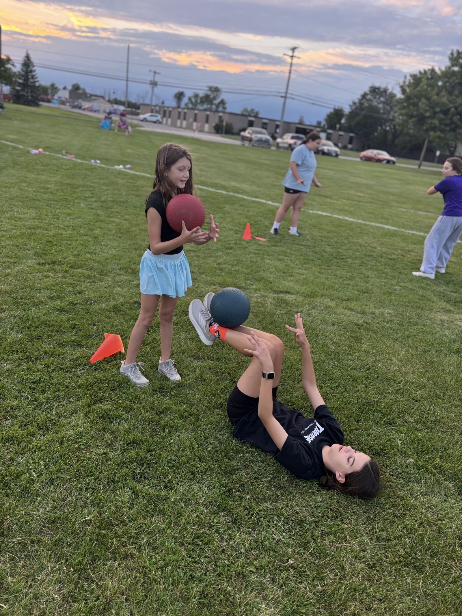 Players work a medicine-ball drill on the grass.