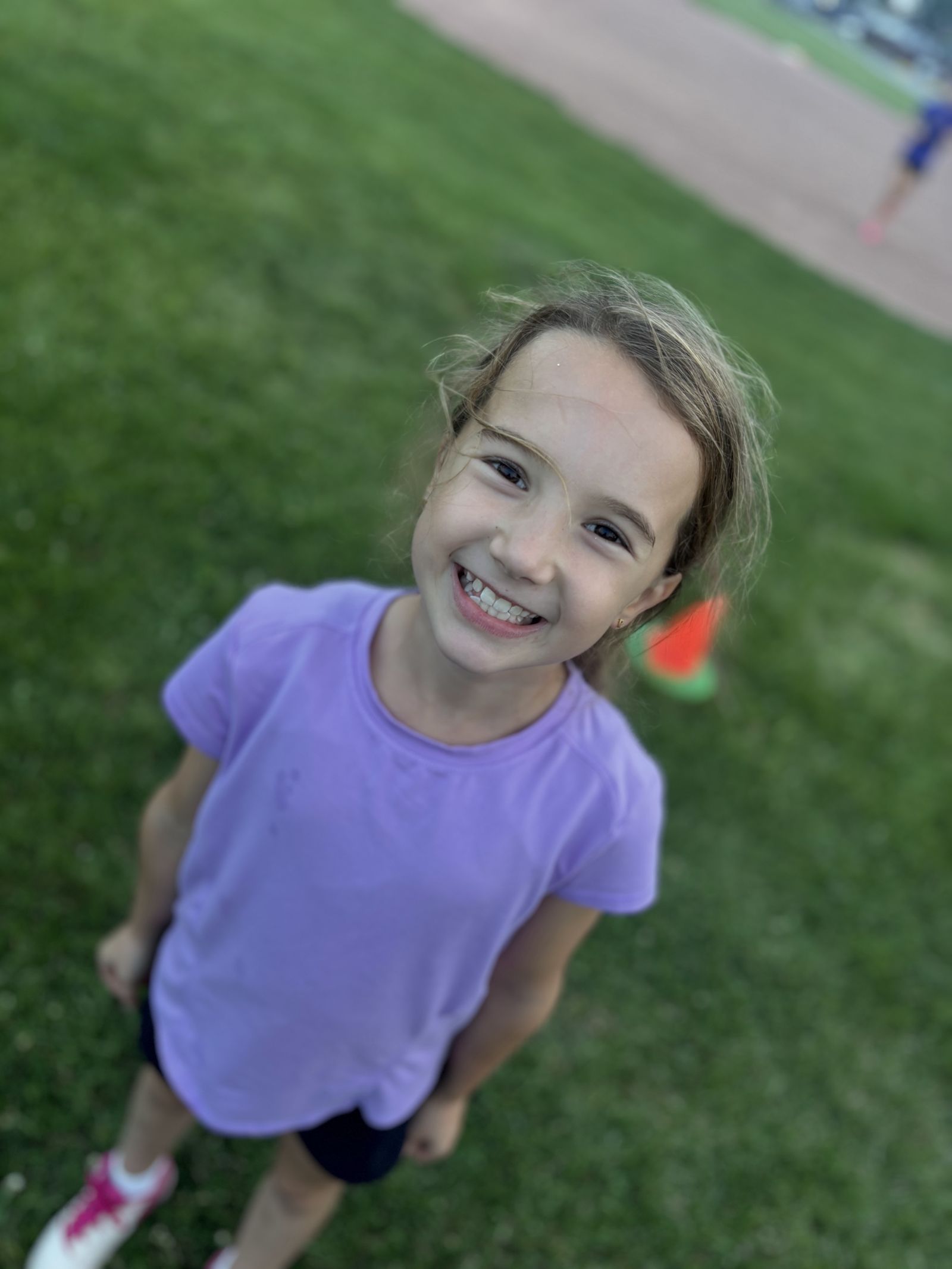 A young player smiles up at the camera at a clinic.