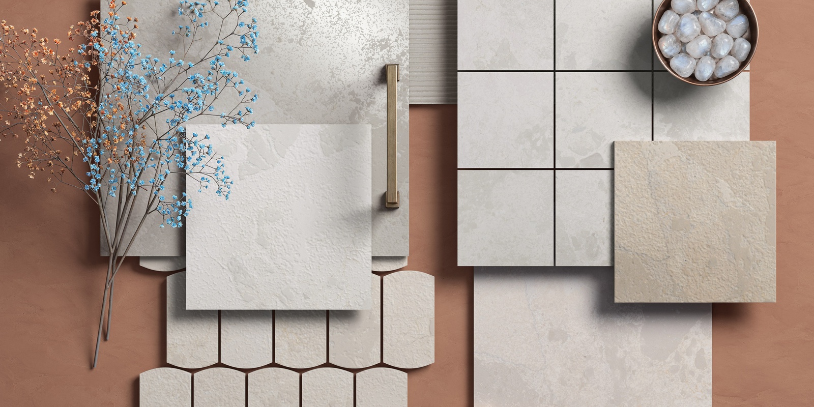 Flat lay of light-textured beige tiles arranged on a brown surface with dried flowers and white stones.