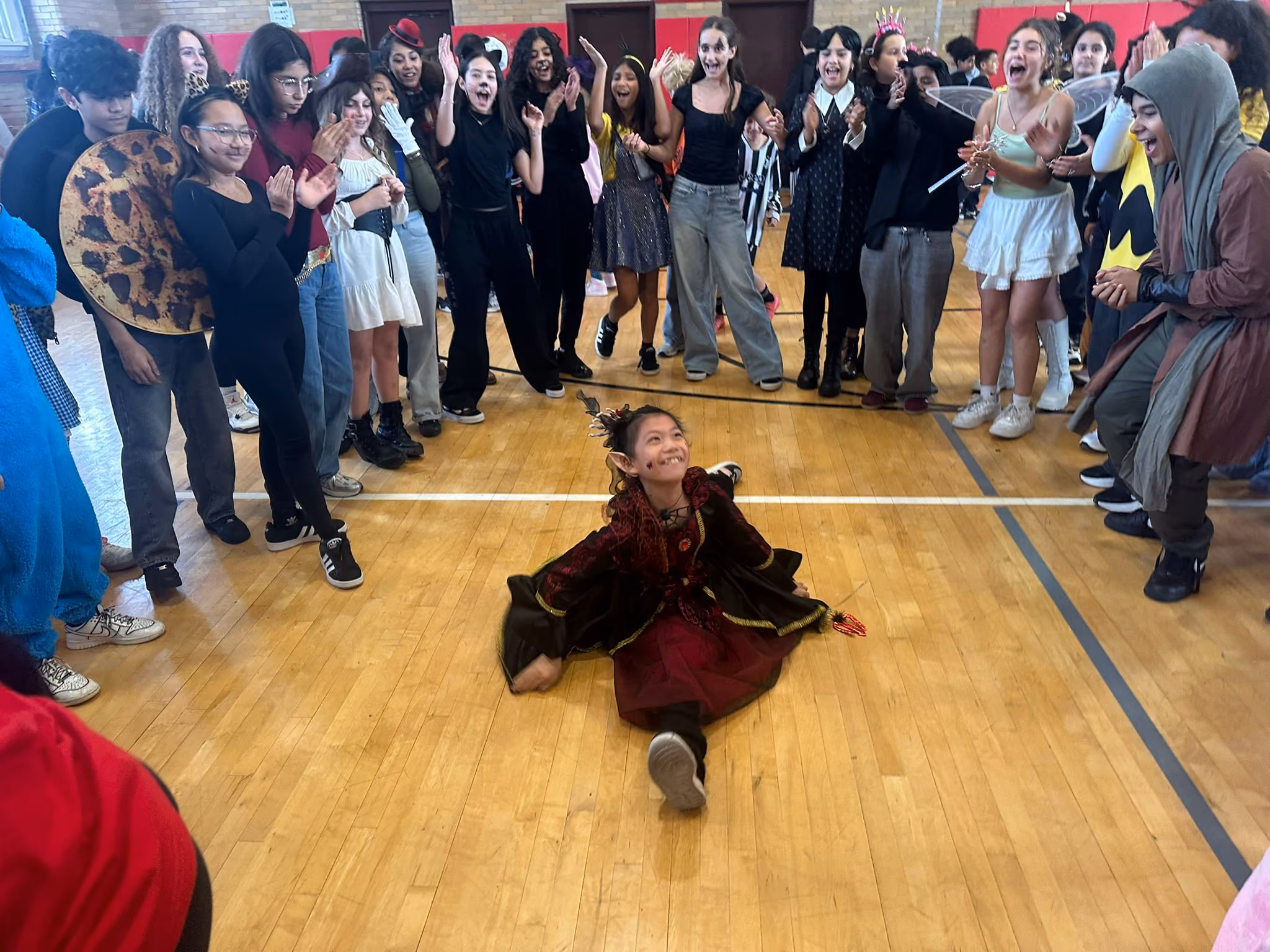 Student in Halloween costume dancing at school gymnasium celebration